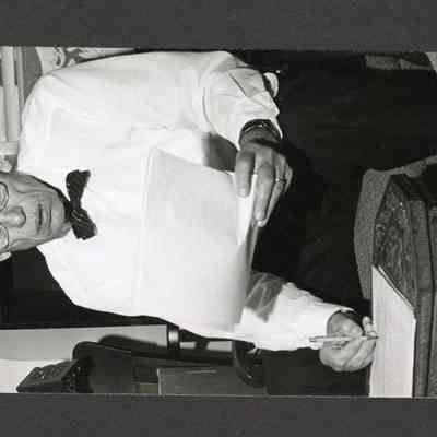 Photograph of Man in Bowtie taking notes, Unknown date and location