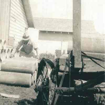 Photograph of worker moving concrete, undated