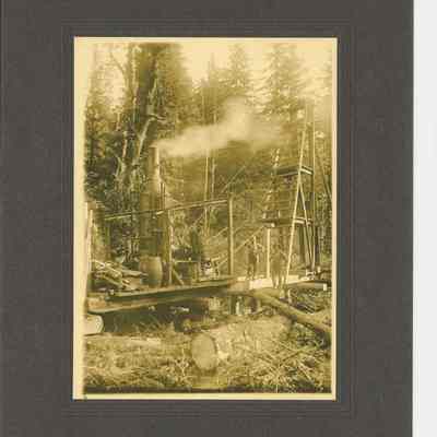 Photograph of Steam Donkey and Cable Tower with three unidentified men, date unknown