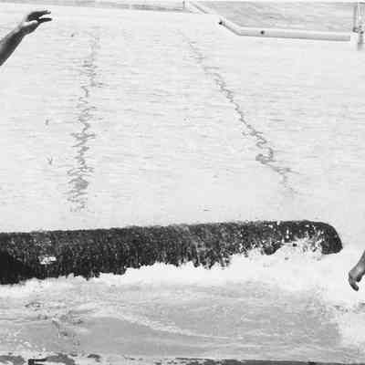 Photograph of two unknown men jumping off log, date unknown