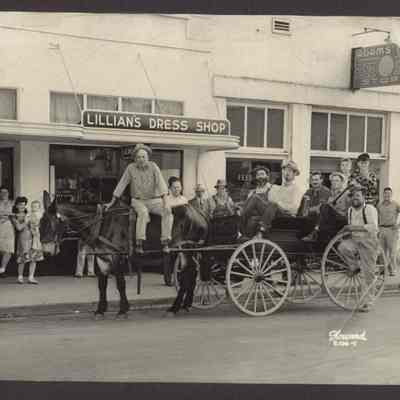Photograph of a group of people outside Lillian's Dress Shop and Adams Feed & Seed Store, Springfield, Oregon, Undated