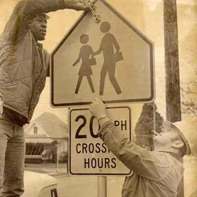Photograph of installation of school zone traffic signs, date unknown.