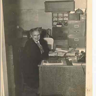 Photograph of an unidentified women at a desk, unknown date