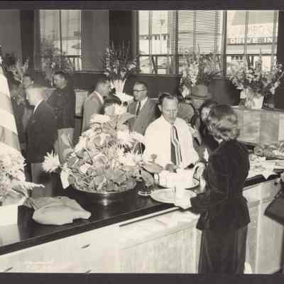 Photograph of a reception. In right rear window across the street is a sign, Jumbo Drive In. Date unknown.