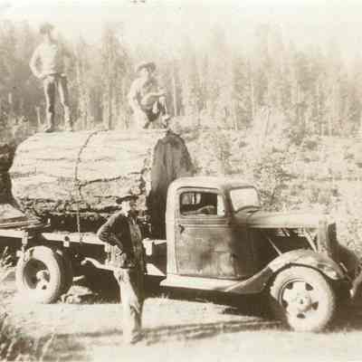 Photograph of three unknown men with a logging truck