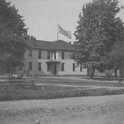 Photograph of school building with large flag, Springfield, Oregon, date unknown.