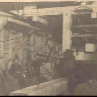 Photograph of four unknown men inside a lumber mill