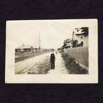 Photograph of unknown boy on sidewalk