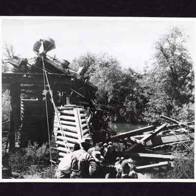 Photograph of Workers trying to keep a train on tracks, unknown date and location