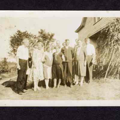 Photograph of a group of people in front of a house, circa 1920