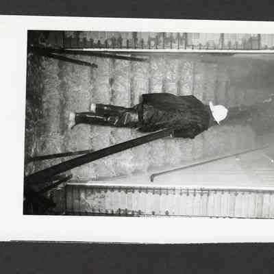 Photograph of Firefighter Carrying Hose Up Stairs, Date Unknown.