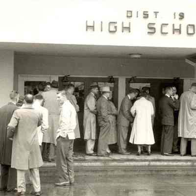 Photograph of people purchasing tickets from booth at High School entrance, date unknown.