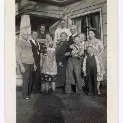Group photograph in front of a house, undated