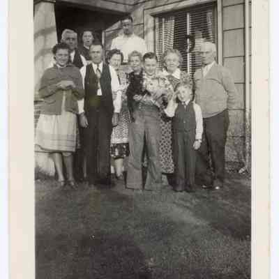 Group photograph in front of a house, undated