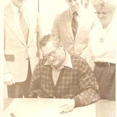 Photograph of Mayor John McCulley with three people standing behind him