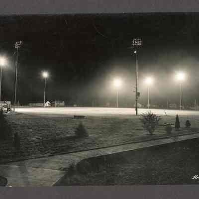 Photograph of an empty football field at night, undated