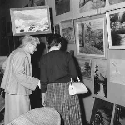 Photograph of two unknown women viewing art exhibit at Shoppers Paradise event, Springfield, Oregon, 1957