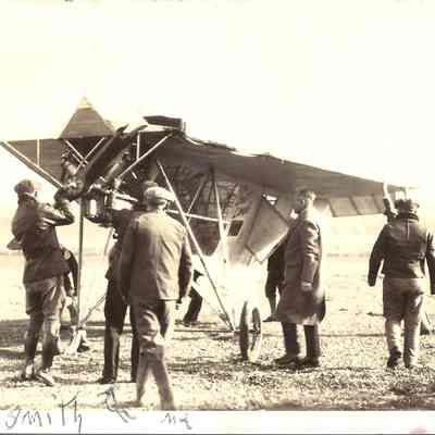Photograph of 7 men around an early aircraft