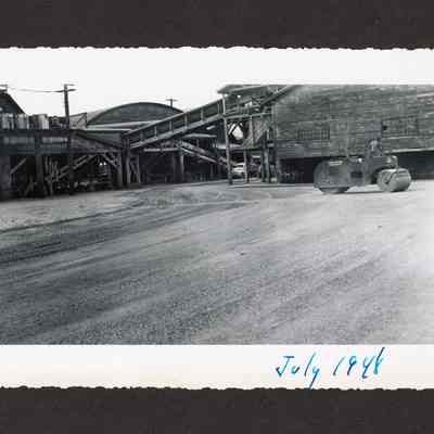Photograph of the filling and paving of the old log pond at Booth-Kelly Lumber Mill