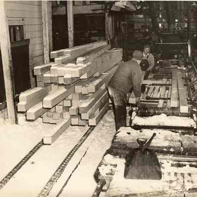 Photograph of workers at a lumber mill during winter, Undated