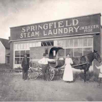 Photograph of five people outside the Springfield, Steam Laundry Building, Springfield, Oregon, 1912