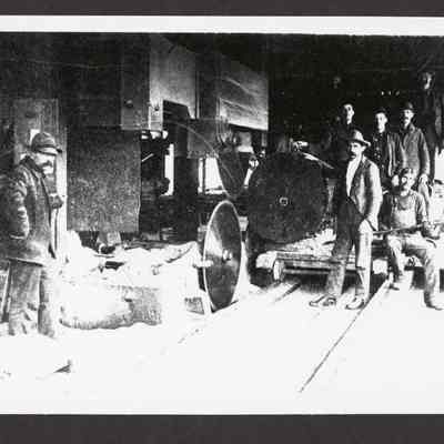 Photograph of eight men around headrig at Hyland Mill