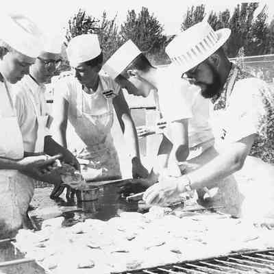 Photograph of five unknown men broiling chicken, date unknown