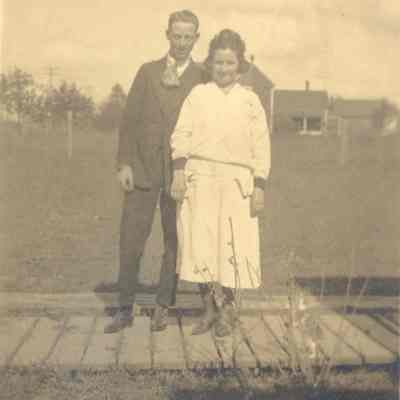 Photograph of two people posing in front of a house, Springfield, Oregon