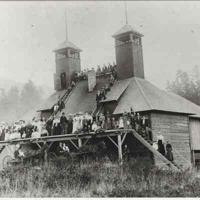 Photograph of a group of people outside a large hop dryer near Lowell, Oregon