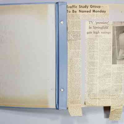 Inside front cover and page 1 newspaper clippings unfolded