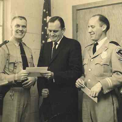 Photograph of four policemen with one unidentified man in suit, date unknown