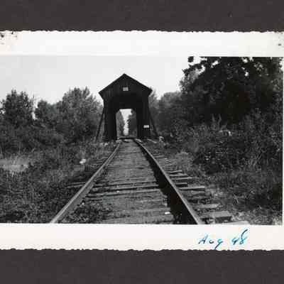 Photograph of railroad tracks and a covered wooden bridge, 1948