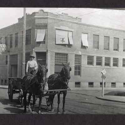 Photograph of a horse and wagon on the street outside Bangs Livery Co.