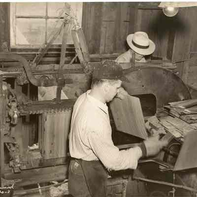 Photograph of 2 men working in a mill, undated