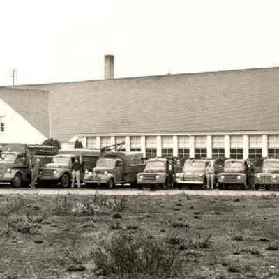 Photograph of trucks and maintenance crews in front of Springfield High School, Springfield, Oregon, date unknown.