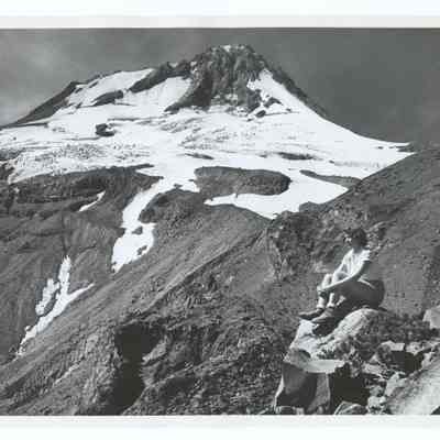 Photograph of a woman sitting on a rock, near Tam McArthur Rim (?), Oregon, undated