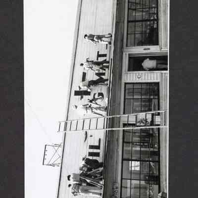Photograph of crew painting new sign, 1957