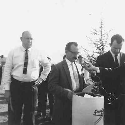 Photograph of three unknown men adding items to Oregon Centennial time capsule, 1959