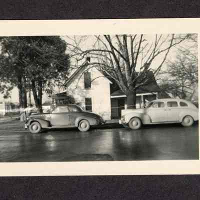 Photograph of Two People and Two Cars, 1950