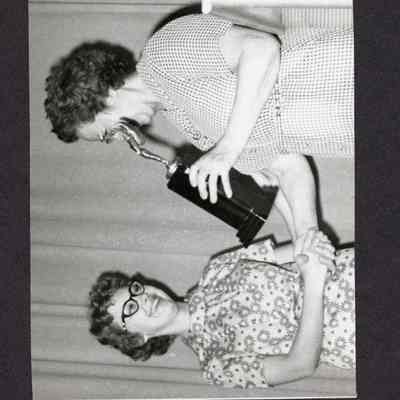 Photograph, Women Shaking Hands, One Holding a Trophy, Date Unknown.