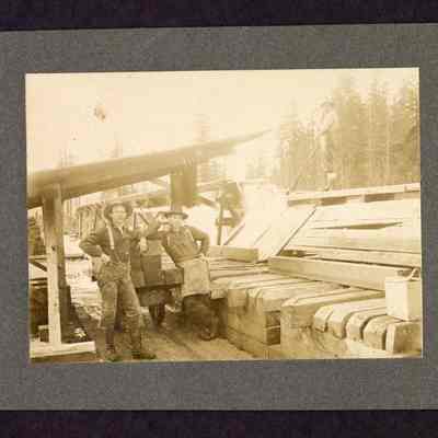 Photograph of three men unloading lumber flume at Fischer planing mill, Marcola, Oregon, circa 1903-1905