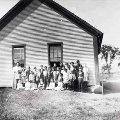 Photograph of students and teacher in front of school, Saginaw, circa 1900