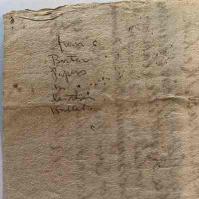 Close up of back of item, “from Burton papers in leather wallet” written in pencil