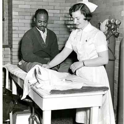 A nurse examines a patient's leg in the Accident Room