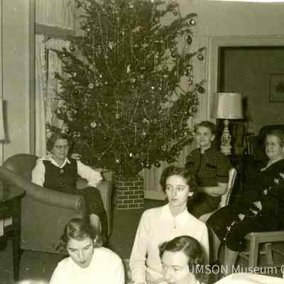 Students seated Parsons Hall living room decorated for Christmas
