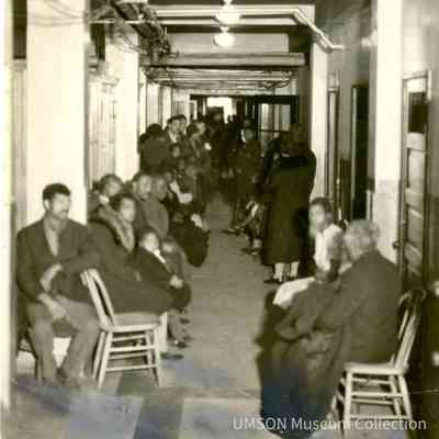 Black patients waiting in a basement hallway, segregated outpatient clinic, University Hospital, Maryland, 1934