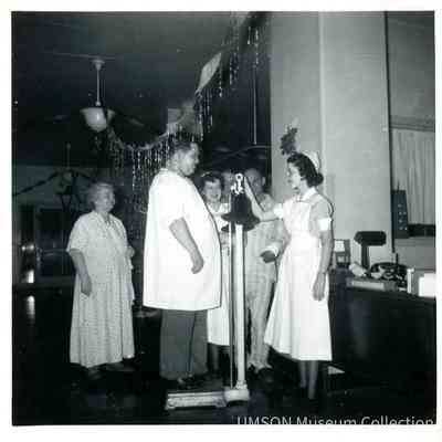 Student nurse weighing a male patient, University Hospital
