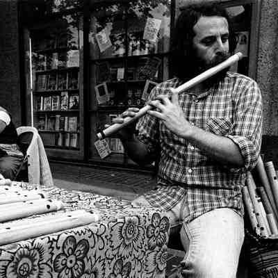 A vendor plays a bamboo flute on Telegraph Ave.