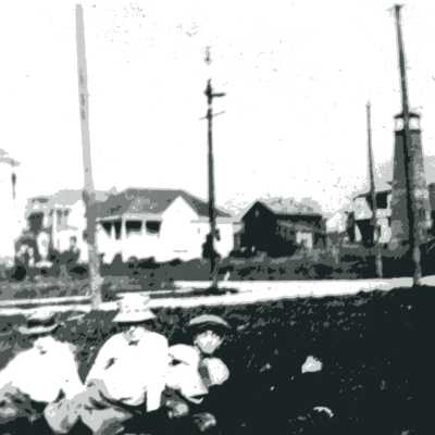 Family seated in empty lot near Henry and Vine Streets