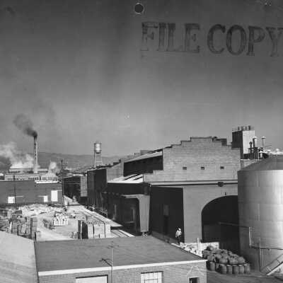Barrels, pallets, tanks, brick building